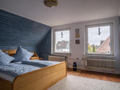 een slaapkamer met een bed en 2 ramen bij Wohlfühlen in Ostseenähe in Ratekau