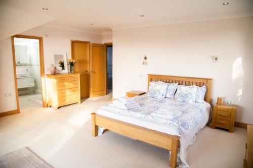 a bedroom with a large bed and a bathroom at 2 Princes Cottages in Plymouth