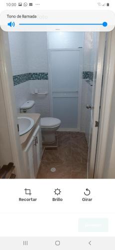 a bathroom with a white toilet and a sink at Casa Francia in Cartagena de Indias