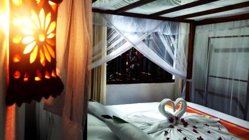 a bed with two swans shaped towels on it at Eagle Homestay in Tangalle