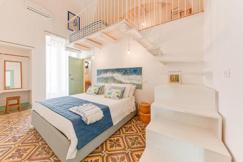 a bedroom with a bed and a staircase at VERDEACQUA CASA VACANZE in Morciano di Leuca