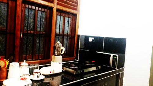 a kitchen with a coffee maker and a microwave at Eagle Homestay in Tangalle