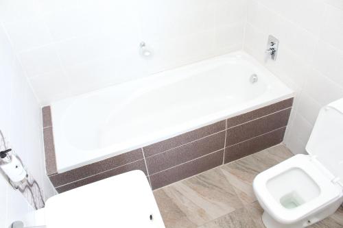 a white bathroom with a toilet and a sink at Max B&B in East London