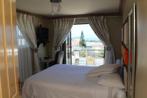 a bedroom with a bed and a large window at Max B&B in East London