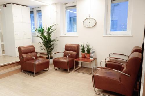 a waiting room with chairs and a clock on the wall at Hotel Doria in Amsterdam