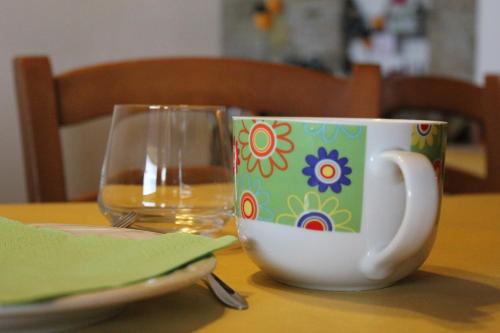a coffee cup and a glass on a table at Agriturismo La Valle del Vento Urbino in Urbino