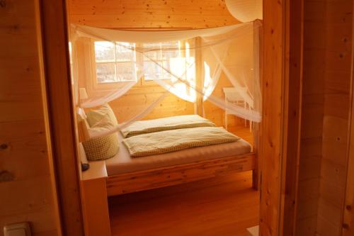 Tempat tidur dalam kamar di Ferienwohnung im gemütlichen Blockhaus vor den Bergen