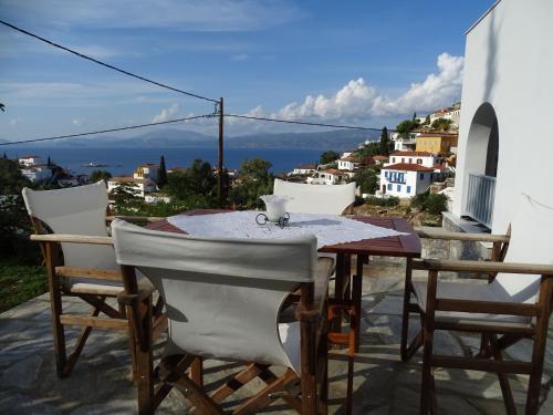 a table and chairs on a balcony with a view at Villa ADA in Hydra