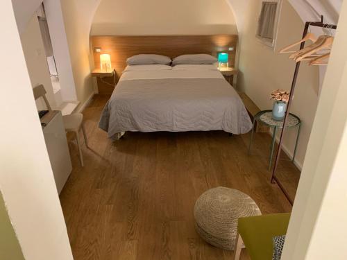 um quarto com uma cama e piso em madeira em VIA DANTE LUXURY em Matino
