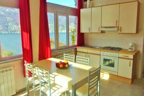- une cuisine avec une table et un bol de fruits dans l'établissement Casa le Palme, à Pino Lago Maggiore