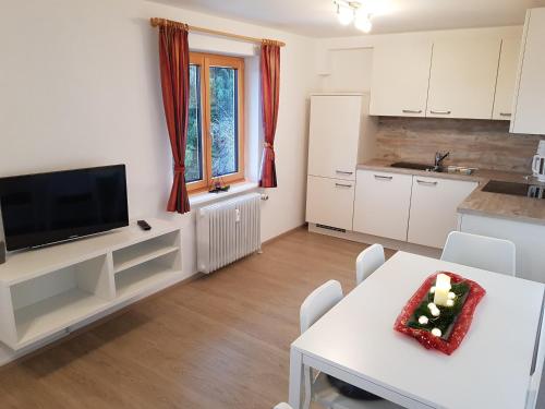 a kitchen and living room with a table with a cake on it at Schönblick Hotel Garni Ferienwohnungen in Lindenberg im Allgäu