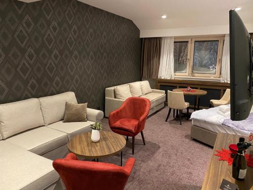 a living room with a couch and a table at Teddy Apartman Kula Konaci in Kopaonik