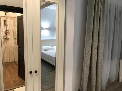 a mirror in a room with a bed and a bedroom at Pensiunea Edelweiss in Voineasa