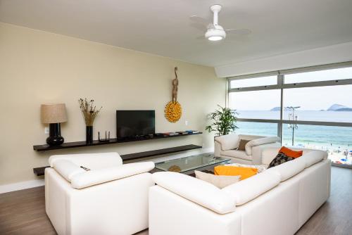 sala de estar con 2 sofás blancos y TV en Vista para o mar em Ipanema - VS401 Z1, en Río de Janeiro