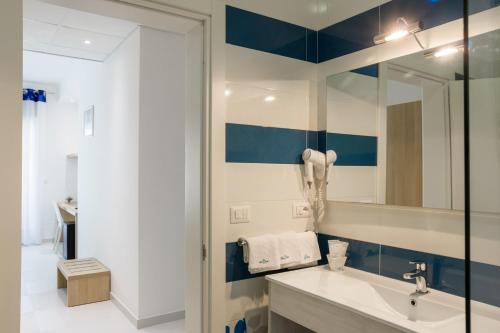 ein Bad mit einem Waschbecken und einem Spiegel in der Unterkunft Gigli Hotel Salento in Marina di Pescoluse