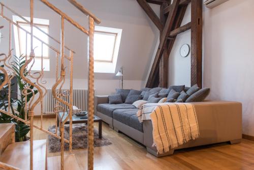 uma sala de estar com um sofá azul num quarto em Comfy loft on Hlavna em Košice