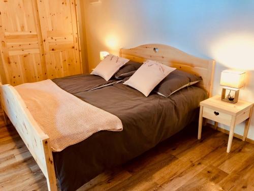 een slaapkamer met een houten bed en een nachtkastje bij Bergidyll an der Lane - Pfunders in Fundres