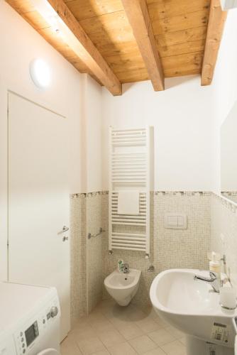 a white bathroom with a sink and a toilet at Comfy loft on Hlavna in Košice