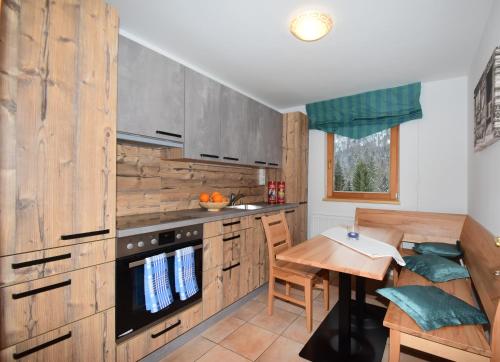 a kitchen with wooden cabinets and a wooden table at Haus Salvenmoser in Walchsee