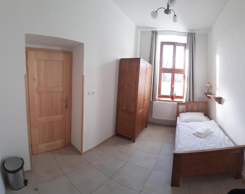 a bedroom with a bed and a window and a door at Penzion a restaurace U Hájků in Nové Dvory
