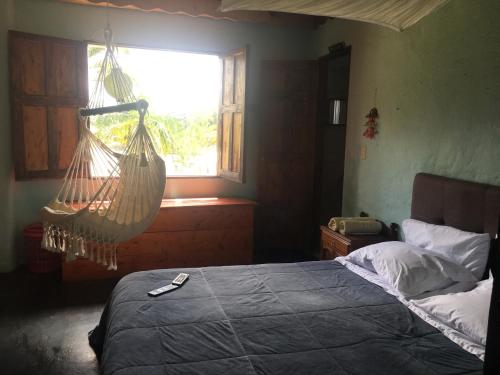 a bedroom with a hammock hanging from a window at Casa finca típica the lake hotel in Guatapé