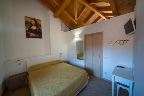 una camera con letto in una stanza con scrivania di Residence SANTABBONDIO a Como