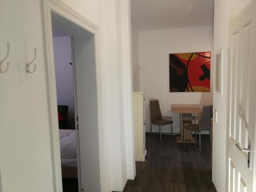 een witte kamer met een tafel en een eetkamer bij Gästewohnung in Cottbus-Klein Ströbitz in Cottbus