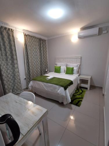 a bedroom with a large bed with green pillows at The Zion Hill in East London
