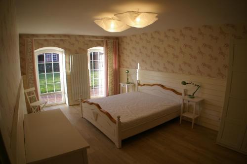 ein Schlafzimmer mit einem Bett und zwei Fenstern in der Unterkunft Ferienwohnung 6 Fam. Ramm in Sibbersdorf