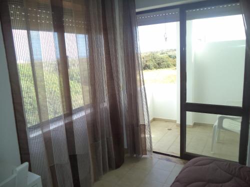 a room with a sliding glass door with a view at Quartos Maria Clara in Sagres