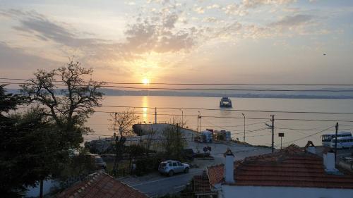 a sunset over a body of water with the sun setting at Dardanelles1915 in Canakkale