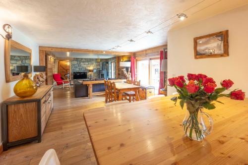 un salon avec un vase de fleurs sur une table dans l'établissement Appartement Marcella, à Montgenèvre