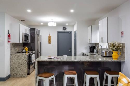 a kitchen with a large counter with stools in it at Casa Madeira @ the heart of Miami Design District in Miami