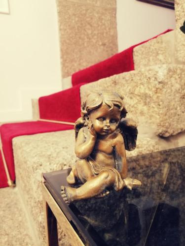 a statue of a little girl sitting on a table at Casa Victória in Ponte da Barca
