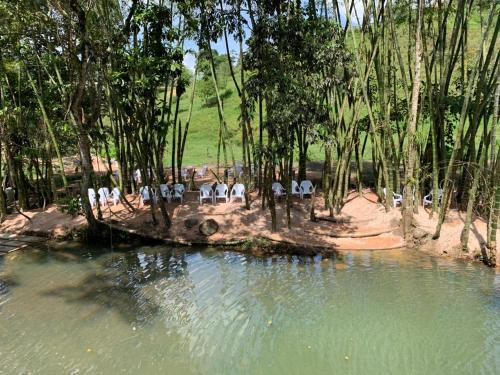 a group of people sitting next to a body of water at Hotel la hacienda del pienta in Charalá