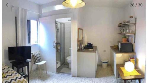 a room with a bathroom with a toilet and a television at 1 person Sea View Studio, en la escalera de San Andres in Santa Cruz de Tenerife