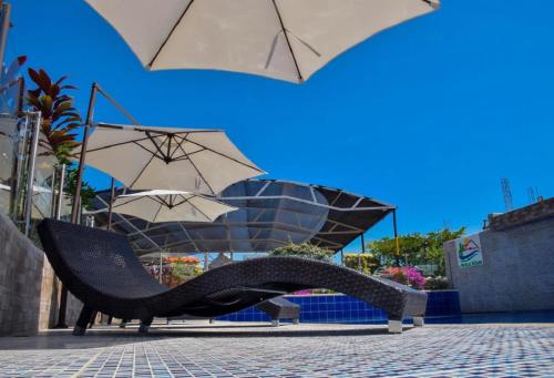 a reclining chair and umbrella on a brick floor at HV Sueño Real Tatacoa in Villavieja