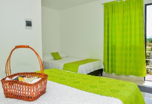 a room with two beds with green curtains and a basket at HV Sueño Real Tatacoa in Villavieja