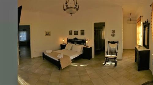 a large bedroom with a bed and a chair at Villa ADA in Hydra