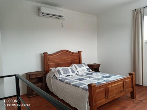 a bedroom with a bed with a blue and white blanket at Bº CERRADO LOMAS DEL REY MAYU SUMAJ in San Antonio de Arredondo