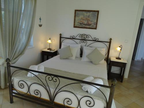 a bedroom with a bed with white sheets and pillows at Villa ADA in Hydra