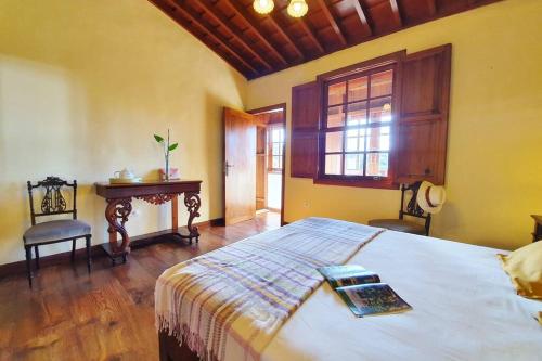 a bedroom with a bed and a window and a table at Casa emblemática in Tegueste