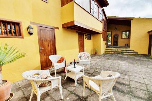 a patio with chairs and tables and a building at Casa emblemática in Tegueste