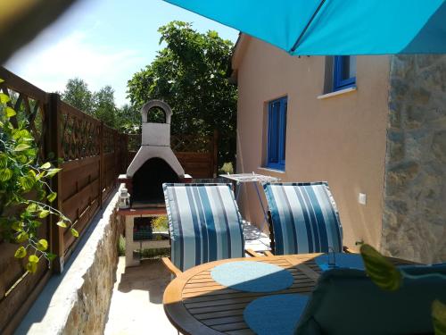 a table and chairs on a patio with a pizza oven at Tiny house in Sukošan