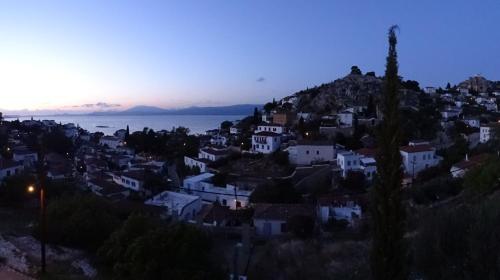 a town on a hill with the ocean in the background at Villa ADA in Hydra