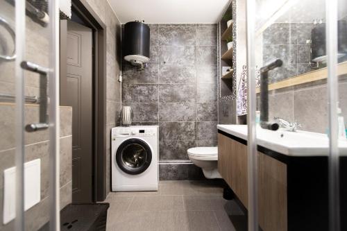 a small bathroom with a washer and dryer in it at Eco apartments 650 meters from subway 55 sq meters in Saint Petersburg