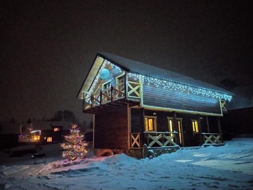 a house with christmas lights on it in the snow at Dobryi Hutsul 2 in Mykulychyn