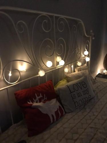 a bed with a head board with lights and pillows at Homestay Khomenko in Perechin