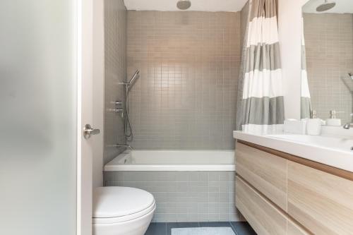 y baño con aseo, bañera y lavamanos. en Gorgeous Park House w Parking on Queen West, en Toronto