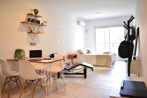 a living room with a table and a bed at Luminosos y modernos departamentos en Rosario in Rosario